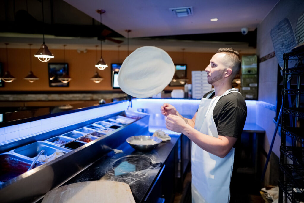 Hand-tossing fresh pizza dough at Espositos Pizza Bar and Restaurant